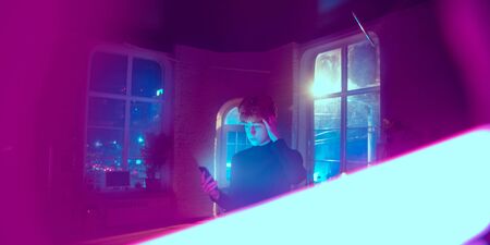 Calm, serious. Cinematic portrait of stylish redhair man in neon lighted interior. Toned like cinema...