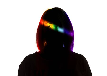 Live. Dramatic portrait of a girl in the dark on white studio background with rainbow colored line. Hidden things, human rights, equality, LGBT peoples pride concept. Art elegance, creative.の写真素材