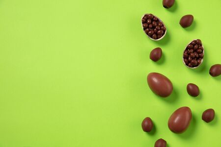 Egg hunt is coming. Easter traditions, chocolate eggs on green background, top view, copyspace for...
