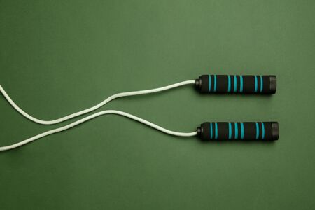 Bright white and green jumping rope. Professional sport equipment isolated on green studio...