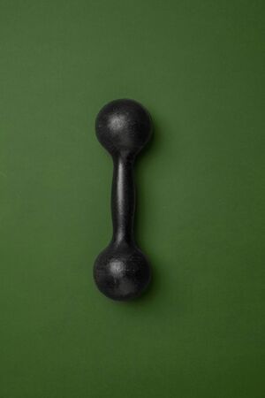 Bright black fitness, bodybuilding weights. Professional sport equipment isolated on green studio...