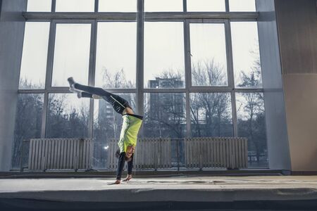 Flying. Little male gymnast training in gym, flexible and active. Caucasian fit little boy, athlete...