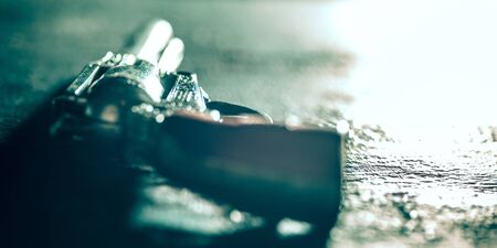 Revolver on stone surface. Close up of old retro things shooted with vintage style colors and toned....