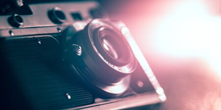 Photo camera on dark background. Close up of old retro things shooted with vintage style colors and toned. Flyer for your ad. Concept of retro style, history return, fashioned things, hobby, memories.の写真素材