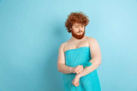 Portrait of young caucasian man in his beauty day and skin care routine. Male model with natural red...