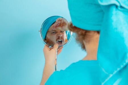 Reflection. Portrait of young caucasian man in his beauty day and skin care routine. Male model with...
