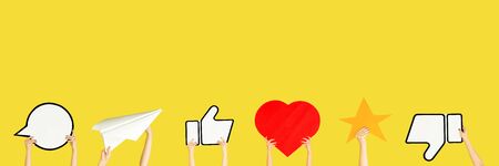 Hands holding the signs of social media on yellow studio background, flyer. Copyspace for your text...