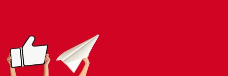 Hands holding the signs of social media on red studio background, flyer. Copyspace for your text or...