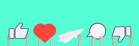 Hands holding the signs of social media on turquoise background, flyer. Copyspace for your text or image, advertising. Showing meaning, gadgets, modern technologies, comments, message, interactions.の写真素材