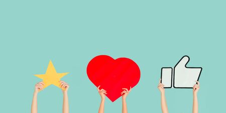 Hands holding the signs of social media on blue studio background, flyer. Copyspace for your text or image, advertising. Showing meaning, gadgets, modern technologies, comments, message, interactions.の写真素材