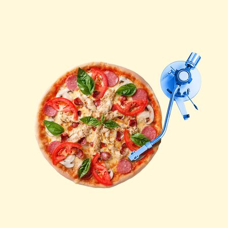 Pizza as a vinyl on DJs controller on yellow background. Copyspace to insert your text. Modern design. Contemporary artwork, collage. Concept of summertime, vacation, resort, mood, beach season.の写真素材