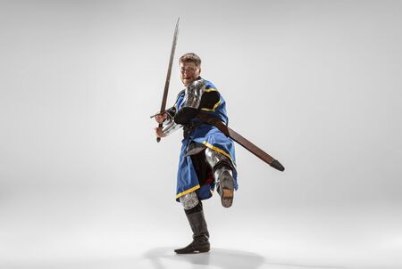 Brave armored knight with professional weapon fighting isolated on white studio background....