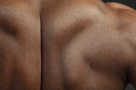 Back. Detailed texture of human skin. Close up shot of young african-american male body. Skincare, bodycare, healthcare, hygiene and medicine concept. Looks beauty and well-kept. Dermatology.の写真素材