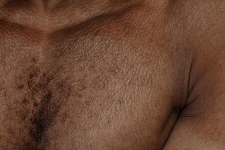 Chest. Detailed texture of human skin. Close up shot of young african-american male body. Skincare, bodycare, healthcare, hygiene and medicine concept. Looks beauty and well-kept. Dermatology.の写真素材