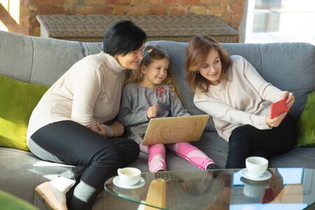 Taking selfie. Happy loving family. Grandmother, mother and daughter spending time together....