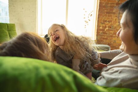 Best emotions. Happy loving family. Grandmother, mother and daughter spending time together. Playing, using tablet, laughting at home. Mothers day, celebration, weekend, holiday and childhood concept.の写真素材