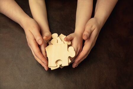 Collecting pazzles, building future. Close up shot of female and kids hands doing different things...