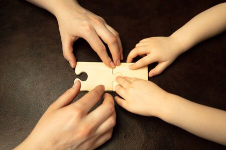 Collecting pazzles, building future. Close up shot of female and kid's hands doing different things...