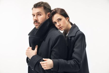 Warmth. Trendy fashionable couple isolated on white studio background. Caucasian woman and man...