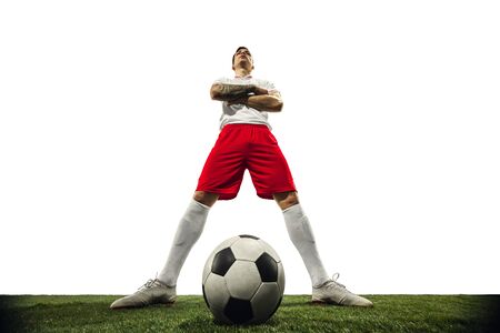 Football or soccer player on white background with grass. Young male sportive model training. Attacking, catching. Concept of sport, competition, winning, action, motion, overcoming. Wide angle.の写真素材