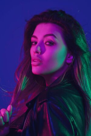Close up, beauty. Caucasian womans portrait isolated on blue studio background in neon light....