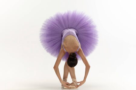 Graceful classic ballerina dancing, posing isolated on white studio background. Bright purple tutu. The grace, artist, movement, action and motion concept. Looks weightless, flexible. Fashion, style.の写真素材
