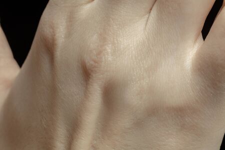 Hands. Detailed texture of human skin. Close up shot of young caucasian female body. Skincare,...