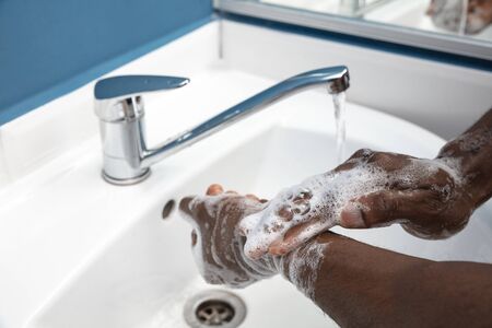 Man washing hands carefully with soap and sanitizer, close up. Prevention of pneumonia virus...