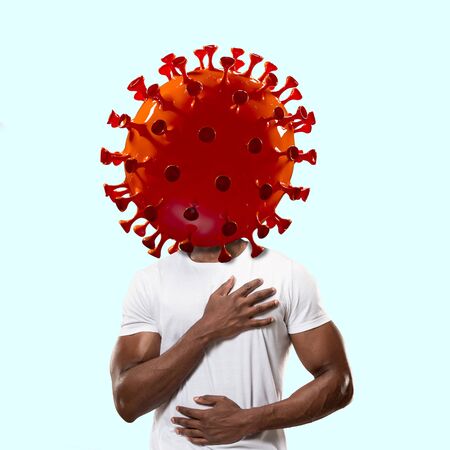 Man headed by model of COVID-19 coronavirus, concept of pandemic spreading, medicine and healthcare. Worldwide epidemic with growth, quarantine and isolation, protection, crisis situation. Feels sick.の写真素材