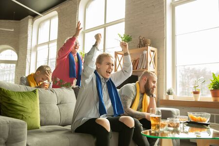 Excited family watching football, sport match at home. Grandparents, parents and kid cheering for favourite national basketball, football, tennis, soccer, hockey team. Concept of emotions, support.の写真素材
