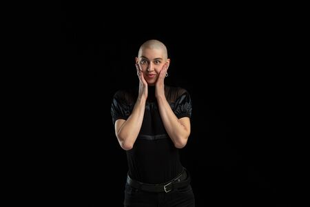 Astonished, cute. Monochrome portrait of young caucasian bald woman isolated on black studio...