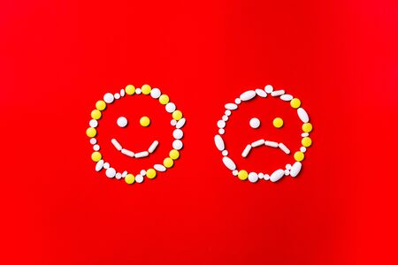 Emotions. Colored pills, tablets and capsules on a red background - history of treatment. Concept of healthcare and medicine, vaccine, protection, prevention of pandemic, epidemic, chronic diseases.の写真素材