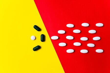 Protection against illness. Colored pills, tablets and capsules on red, yellow background - history...