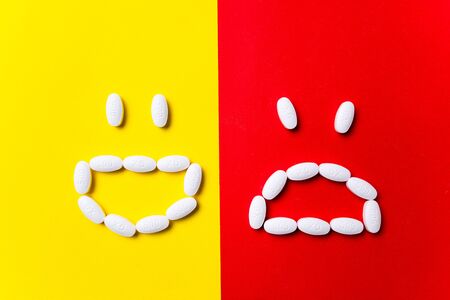 Protection against illness. Colored pills, tablets and capsules on red, yellow background - history...