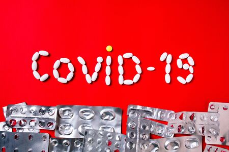 Weapon against COVID-19. Colored pills, tablets and capsules on a red background - history of treatment. Concept of healthcare and medicine, vaccine, prevention of pandemic, epidemic, chronic diseases.の写真素材
