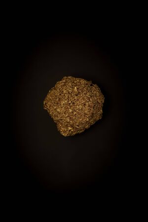 Golden stone on a black background, stylish minimalistic composition with copyspace for ad....