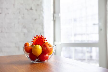 Coronavirus hiding in usual things - check cleanse and freshness of your fruits and food. One of the bunch. Apples, oranges, lemons on the kitchens table. Pandemic, epidemic concept, disinfecting.