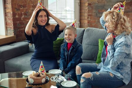 Cake eating. Mother, son and sister at home having fun. Holidays, family, comfort, cozy concept,...