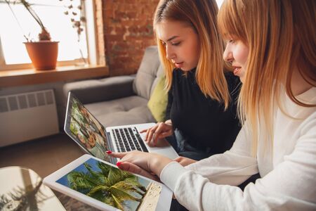 Best memories. Young friends, women using gadgets to watch cinema, photos, online courses, taking...