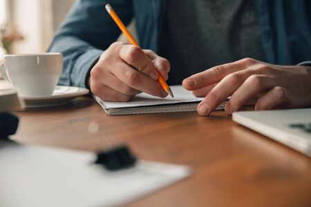 Creative workplace - organized work space as you like for inspiration. Man working in office in comfortable attire, relaxed position and messy table. Choose atmosphere you want - ideal clear or chaos.の写真素材