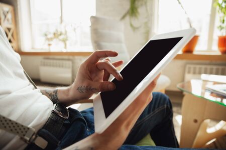 Close up of male hands using tablet with blank screen, copyspace. Surfing, online shopping, scrolling, betting, working. Education, freelance, art and business concept. Watching cinema, reading book.の写真素材