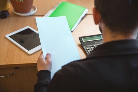 Paperwork, close up. Caucasian entrepreneur, businessman, manager working concentrated in office....