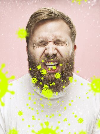 Caucasian man sneezing, illustration of virus spreading, stop epidemic. Ill and fever, headache. Human emotions, sales, healthcare and medicine concept. Stop epidemic. Self-insulated, feels sick.の写真素材