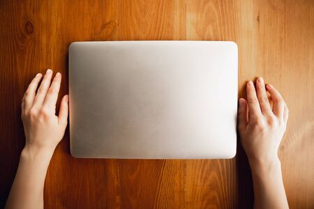 Closed laptop. Close up of caucasian female hands, working in office. Concept of business, finance,...