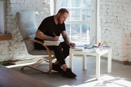 Young man studying at home during online courses for teacher, medical service manager. Getting...