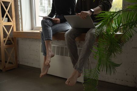 Close up of two people, couple using smartphone, laptop, smartwatch, education and business concept,...