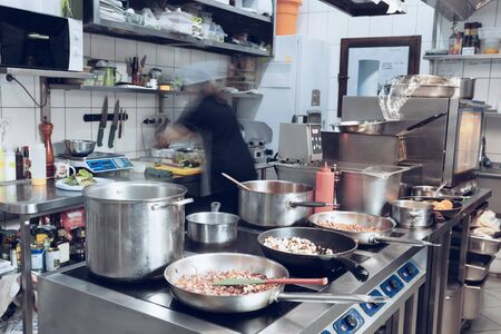 Behind the scenes of brands. The chef cooking in a professional kitchen of a restaurant meal for...