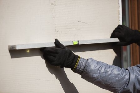Closeup of repairman in uniform, professional builder working using construction equipment. Process...