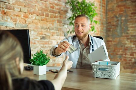 Doctor consulting for patient, working, treating. Caucasian doctor during his work with patients,...