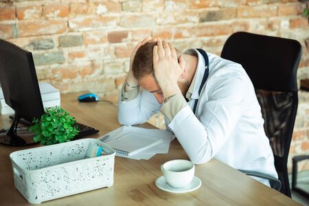 Doctor resting after consulting for patient, working. Caucasian doctor during his work with...